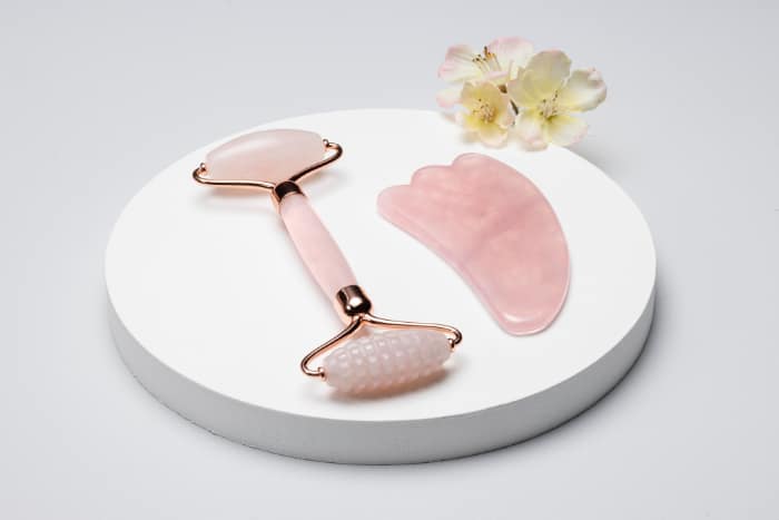 roze gezichtsroller en gua sha