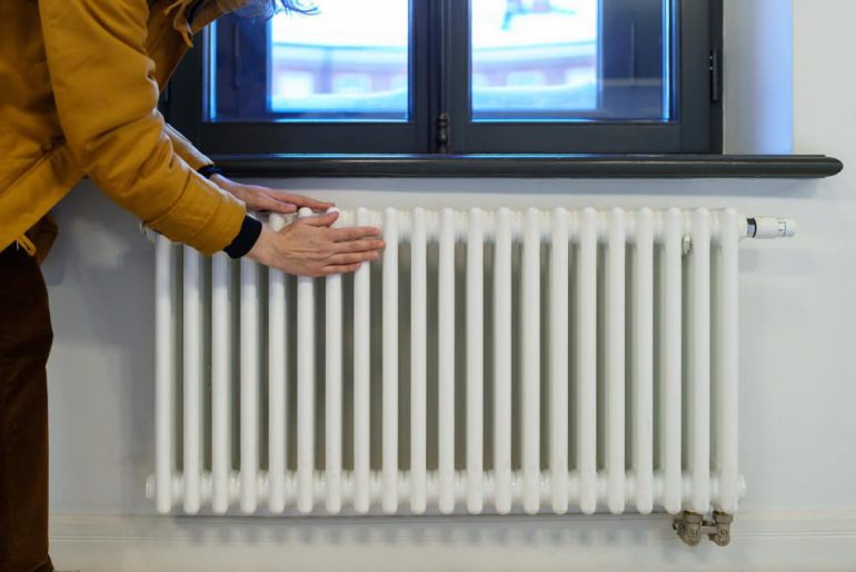 vrouw voelt aan radiator