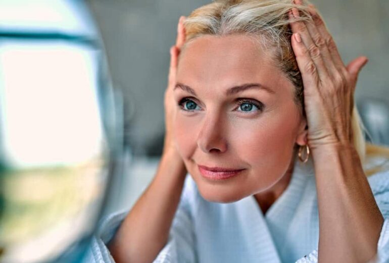 vrouw bekijkt huid in spiegel