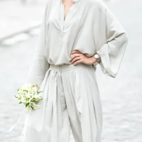 Vrouw met jumpsuit en bruidsboeket