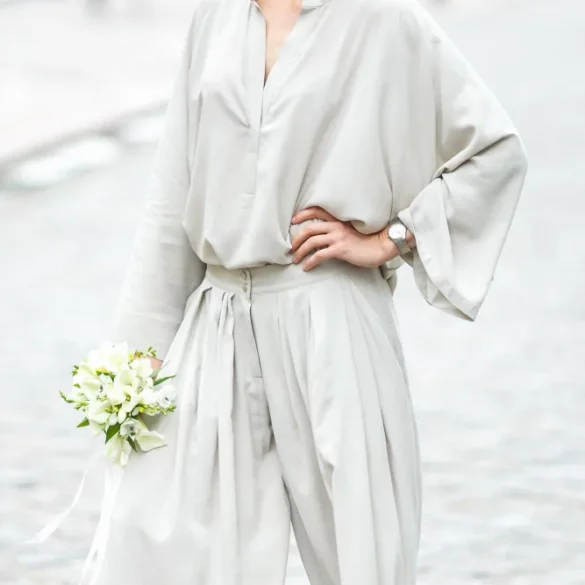 Vrouw met jumpsuit en bruidsboeket