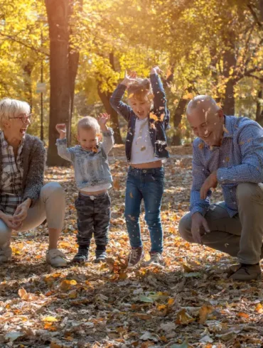 Grootouders met kleinkinderen in een zonnig bos in de herfst