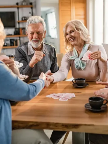 Groep van vier ouderen die samen een kaartspel spelen
