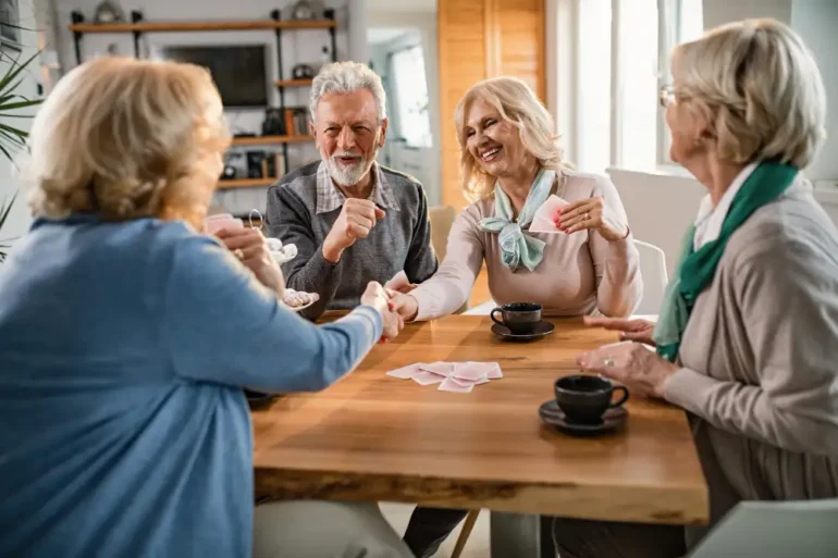 Groep van vier ouderen die samen een kaartspel spelen